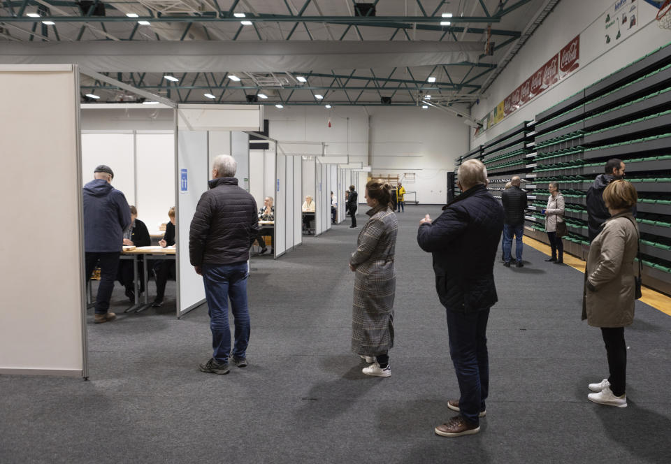 People vote at a local sports complex in Kopavogur, Iceland, Saturday, Sept. 25, 2021. Icelanders are voting in a general election dominated by climate change, with an unprecedented number of political parties likely to win parliamentary seats. (AP Photo/Arni Torfason)