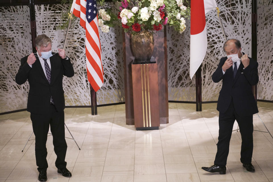 U.S. Special Representative for North Korea Stephen Biegun, left, and Japanese Vice Foreign Minister Takeo Akiba, right, take off their protective masks for a photo session prior to their bilateral meeting at Iikura Guest House Thursday, July 9, 2020, in Tokyo. (AP Photo/Eugene Hoshiko, Pool)