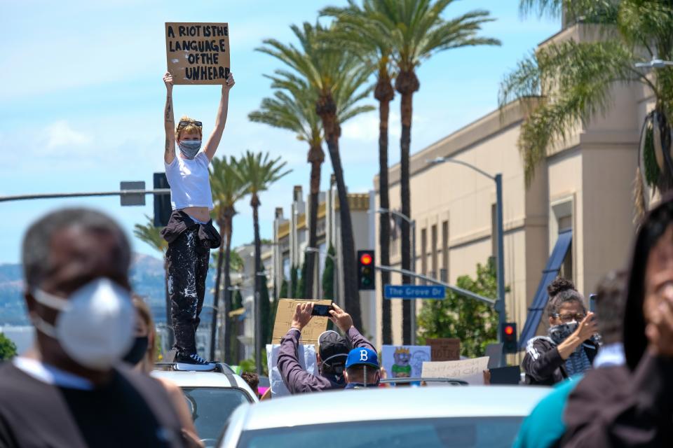 A protestors stands on a car in stopped traffic in Los Angeles on March 30. Photo by Stacey Leasca.