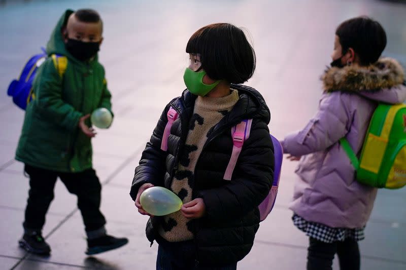 Imagen de archivo. Niños con mascarillas en estación de trenes en Shanghái