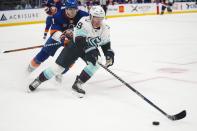 New York Islanders' Noah Dobson (8) fights for control of the puck with Seattle Kraken's Ryan Donato (9) during the third period of an NHL hockey game Tuesday, Feb. 7, 2023, in Elmont, N.Y. The Islanders won 4-0. (AP Photo/Frank Franklin II)