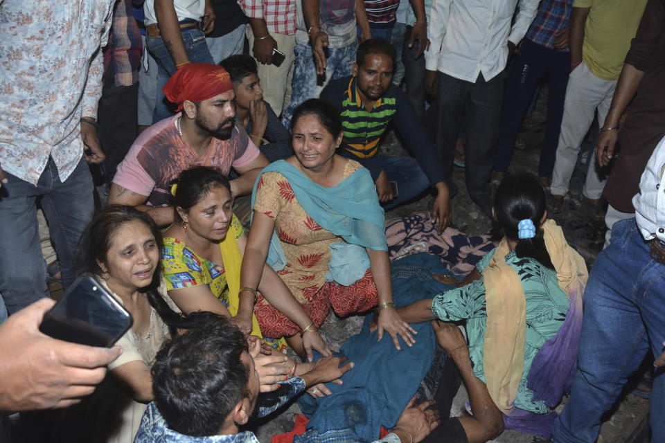 Familiares de una de las víctimas que fueron atropelladas por un tren en las afueras de Amritsar, en el estado de Punjab, en India, lloran a su ser querido al lado de su cadáver, el viernes 19 de octubre 2018. (AP Foto/Prabhjot Gill)