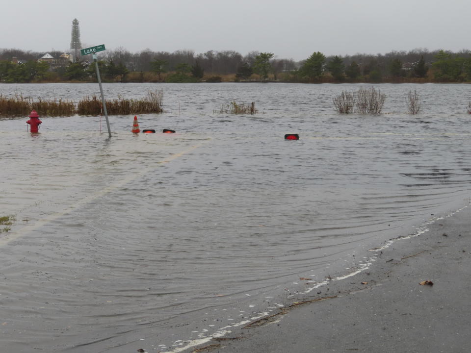 Lake Avenue in Bay Head, N.J. is flooded during a storm on Monday, Dec. 18, 2023 that sent Twilight Lake spilling into the roadway. Communities up and down the East Cast were dealing with flooding and high winds from the storm. (AP Photo/Wayne Parry)