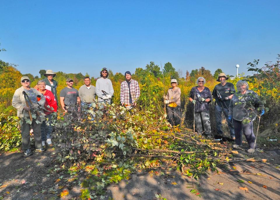 Volunteers (L-R) Brenda Meese, Karen Graham, Ken Shafer, Rob Cunningham, Sheriff Travis Hutchinson, David Graham, Joe Reed, Suzie Lux, Jean Rochester, Mike Edington, and Carole Van Pelt take a break from clearing out invasive species from the meadow in Barnes Preserve.