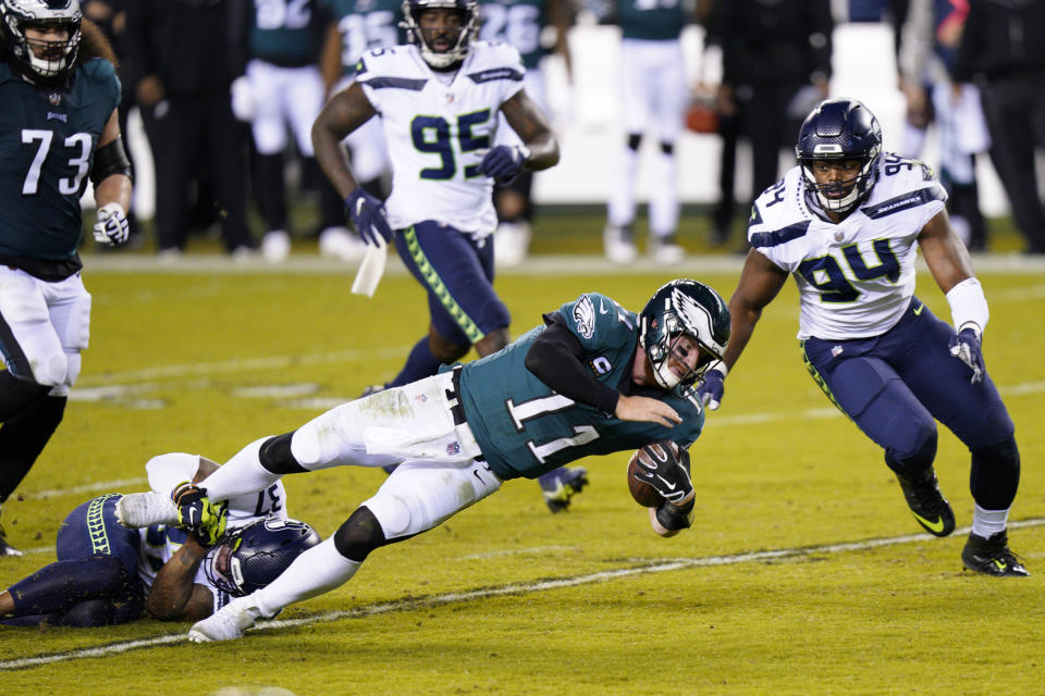 Philadelphia Eagles' Carson Wentz (11) is tackled by Seattle Seahawks' Quandre Diggs (37) during the first half of an NFL football game, Monday, Nov. 30, 2020, in Philadelphia. (AP Photo/Chris Szagola)