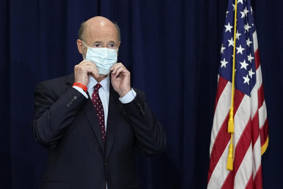 FILE - In this Nov. 4, 2020, file photo, Pennsylvania Gov. Tom Wolf adjusts his face mask to protect against COVID-19 during a news conference in Harrisburg, Pa. Republican lawmakers across the country have tried to roll back the emergency powers that governors wielded during the COVID-19 pandemic, as they ordered businesses and schools shut and mask-wearing in public. On Tuesday, May 18 Pennsylvania’s GOP-controlled Legislature is taking its case to voters, in twin constitutional amendments on the primary ballot that would give lawmakers much more power over disaster declarations, whether another pandemic or a natural disaster. (AP Photo/Julio Cortez, File)