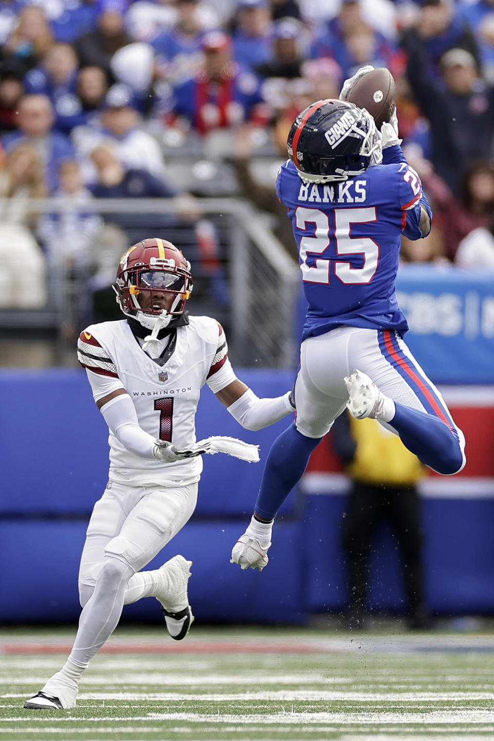 New York Giants cornerback Deonte Banks (25) intercepts a pass intended for Washington Commanders wide receiver Jahan Dotson (1) during the second quarter of an NFL football game, Sunday, Oct. 22, 2023, in East Rutherford, N.J. (AP Photo/Adam Hunger)