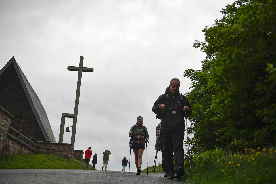 Pilgrims of St. James Way walk at the area of Ibaneta mountain, near to Roncesvalles, northern Spain, Tuesday, June 1, 2021. The pilgrims are trickling back to Spain's St. James Way after a year of being kept off the trail due to the pandemic. Many have committed to putting their lives on hold for days or weeks to walk to the medieval cathedral in Santiago de Compostela in hopes of healing wounds caused by the coronavirus. (AP Photo/Alvaro Barrientos)