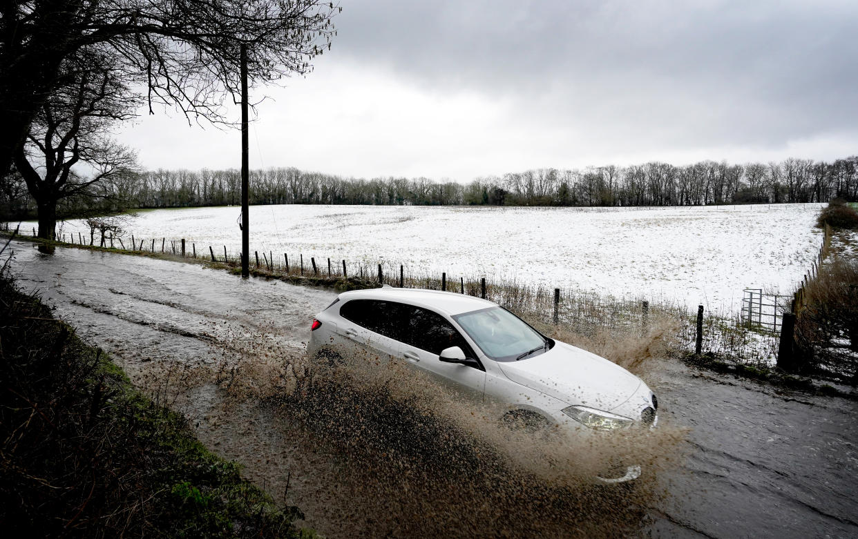 A car passes through flood waters next to a snow covered field near Wrotham in Kent. Kent. Picture date: Monday January 16, 2023. (Photo by Gareth Fuller/PA Images via Getty Images)