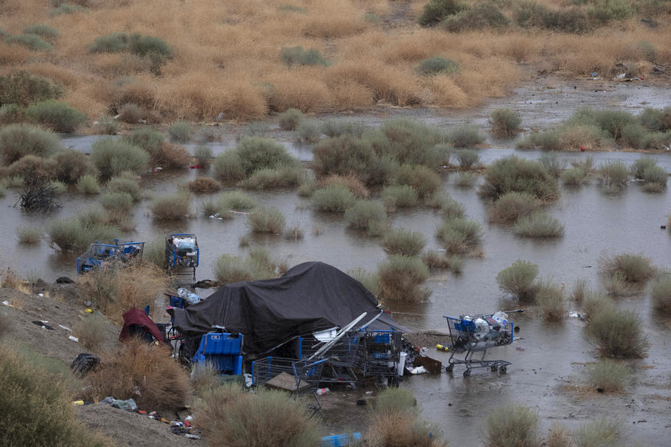 A flooded homeless encampment is seen along California Route 14 in Palmdale, Calif., as a tropical storm moves into the area, Sunday, Aug. 20, 2023. Forecasters said Tropical Storm Hilary was the first tropical storm to hit Southern California in 84 years, bringing the potential for flash floods, mudslides, isolated tornadoes, high winds and power outages. (AP Photo/Richard Vogel)