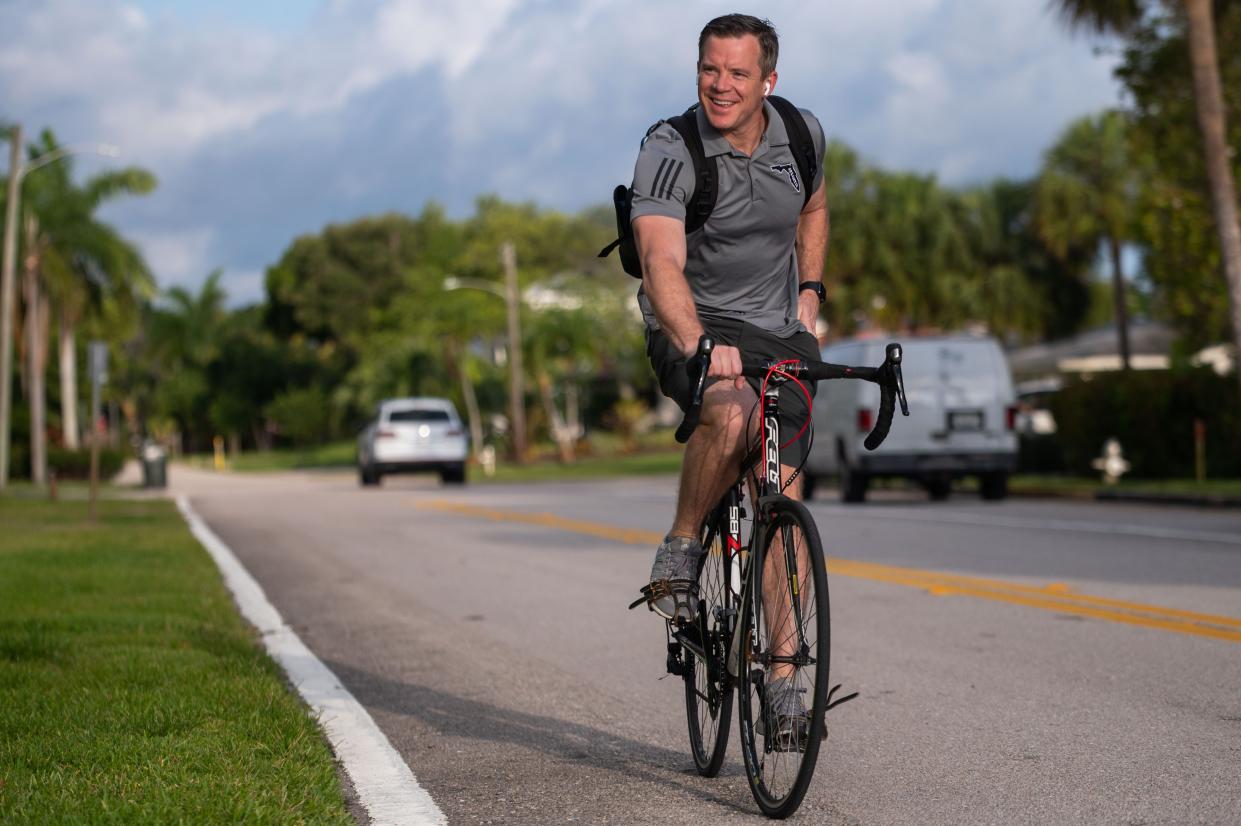 Florida Atlantic men's basketball head coach Dusty May rides his bicycle east on Northwest Sixth Street during his daily cycling commute to FAU on Thursday, April 27, 2023 in Boca Raton, Fla. On most days, May rides his bicycle, a Felt road bike purchased during May's Louisiana days, to work at the Eleanor R. Baldwin Arena on FAU campus.