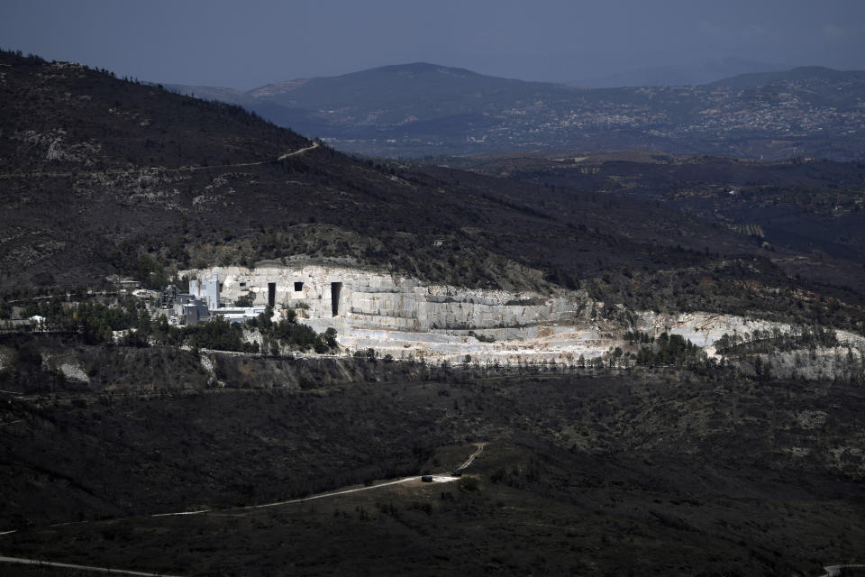 The blackened forests around a marble quarry, which had been burned in a mid-August wildfire, are seen at Dionysos northern suburb of Athens, Thursday, Aug. 22, 2024. (AP Photo/Thanassis Stavrakis)