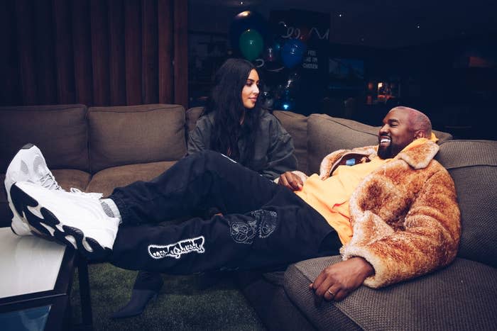 Kim Kardashian West and Kanye West siting on couches at the Travis Scott Astroworld Tour