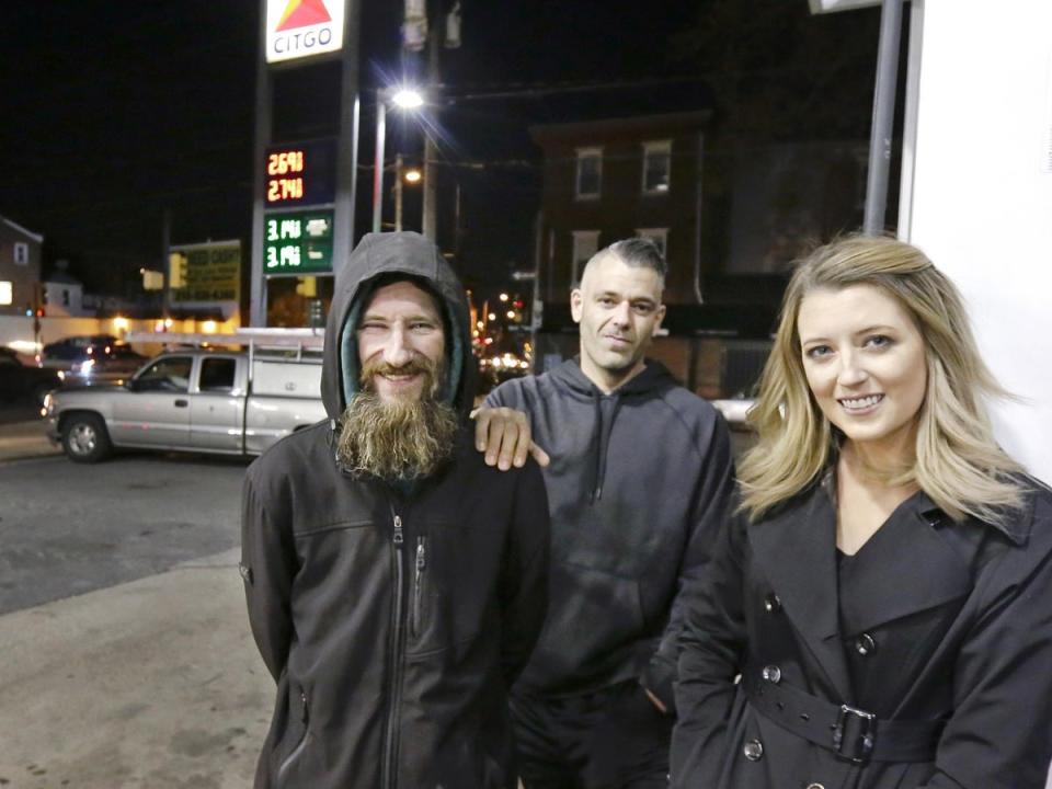 Johnny Bobbitt Jr, left, Kate McClure, right, and McClure's boyfriend Mark D'Amico pose at a Citgo station in Philadelphia (AP)