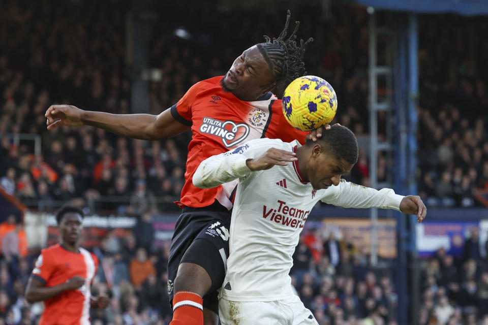 Luton Town's Teden Mengi, left, jumps for the ball with Manchester United's Marcus Rashford during the English Premier League soccer match between Luton Town and Manchester United at Kenilworth Road, in Luton, England, Sunday, Feb. 18, 2024. (AP Photo/Ian Walton)