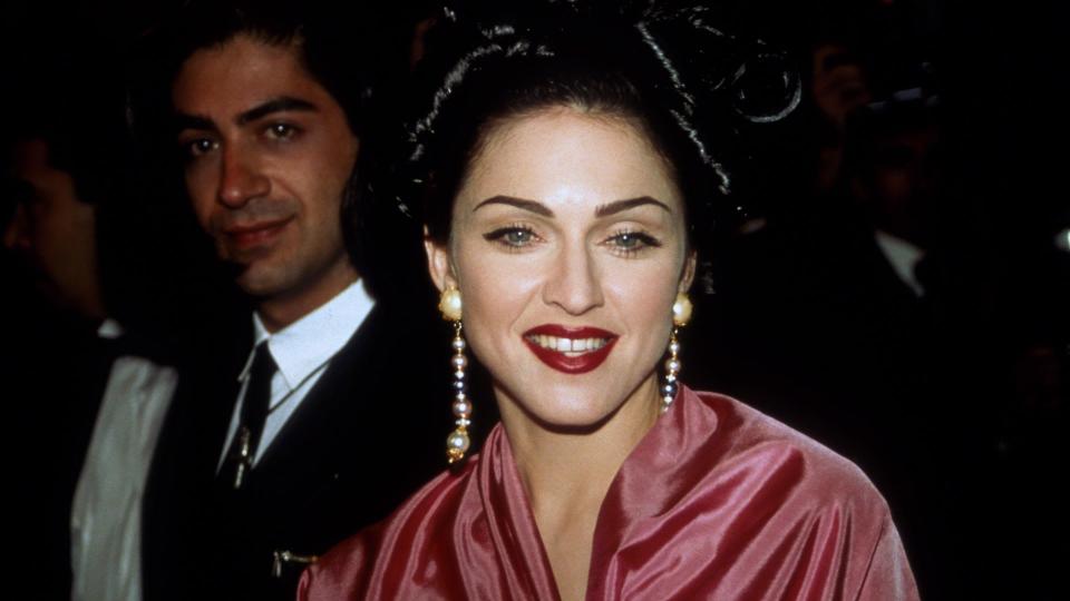 Madonna wearing crimson lipstick and drop down earrings 