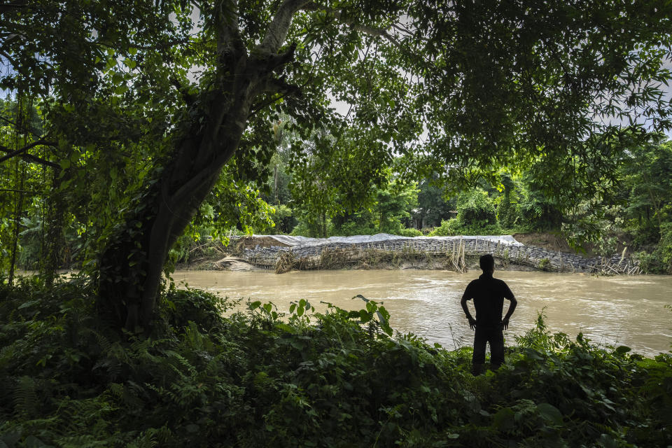 A villager looks at a damaged embankment of Puthimari river in Barama village west of Guwahati, India, Friday, June 23, 2023. Tens of thousands of people have moved to relief camps with one person swept to death by flood waters caused by heavy monsoon rains battering swathes of villages in India’s remote northeast this week, a government relief agency said on Friday. (AP Photo/Anupam Nath)