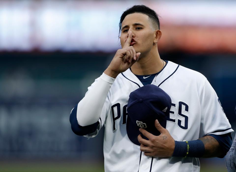 The Padres' Manny Machado gestures toward teammates.