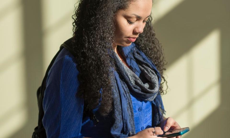 Woman using cell phone by window