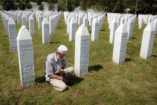 A man prays between grave stones in Potocari, near Srebrenica 