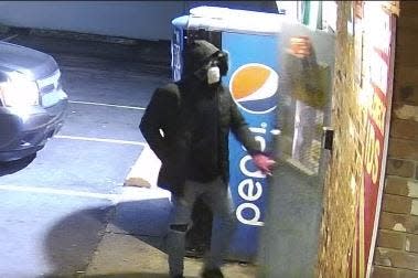 Police are searching for this suspect, shown entering the M&S Drive-Thru moments before three people were shot, one fatally, on Thursday night.