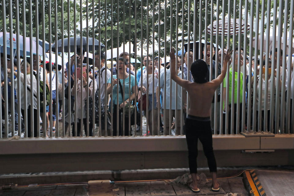 A pro-democracy protester, front, argue with pro-China's supporters during a rally outside Legislative Council Complex in Hong Kong, Sunday, June 30, 2019. Pro-China's supporters rallied in support of the police at Tamar Park (AP Photo/Kin Cheung)