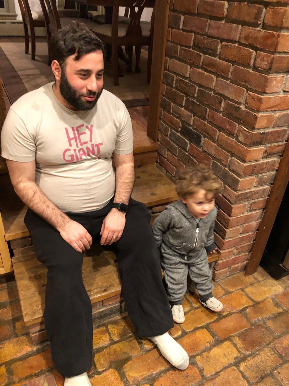 brody, with large belly, sitting next to toddler son