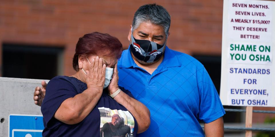 Carolina Sanchez, left, is comforted by her oldest son, Saul Jr., during a protest staged by the union representing employees at a Colorado meatpacking plant where six workers died of COVID-19 and hundreds more were infected this past spring, outside the offices of the Occupational Safety and Health Administration Wednesday, Sept. 16, 2020, in downtown Denver