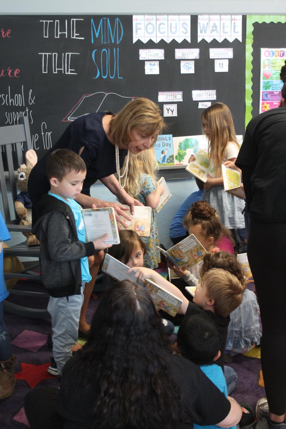 Ohio First Lady Fran DeWine hands out copies of "Peter Rabbit" to the preschool students at Nurture Preschool and Childcare in Byesville.