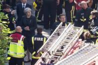 <p>Prime Minister Theresa May speaks to Dany Cotton, Commissioner of the London Fire Brigade, with members of the fire service as she visits Grenfell Tower, on June 15, 2017 in London, England. (Photo: Dan Kitwood/Getty Images) </p>