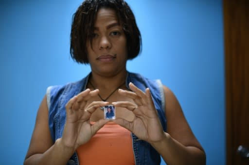 Ruth Perez, 35, poses with a picture of her late brother Jesse in Caracas -- she has also lost two nephews and a brother-in-law