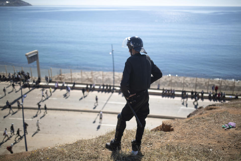 A member of Moroccan security forces stands guard at a hill overlooking the border of Morocco and Spain as Moroccan and sub-saharan migrants attempt to enter the Spanish enclave of Ceuta, on Wednesday, May 19, 2021. Spain’s north African enclave of Ceuta has awakened to a humanitarian crisis after thousands of migrants who crossed over from Morocco spent the night sleeping where they could find shelter. (AP Photo/Mosa'ab Elshamy)