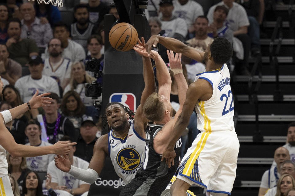 Golden State Warriors forward Andrew Wiggins (22) blocks a shot by Sacramento Kings forward Domantas Sabonis (10) in the second quarter during Game 1 in the first round of the NBA basketball playoffs in Sacramento, Calif., Saturday, April 15, 2023. (AP Photo/José Luis Villegas)