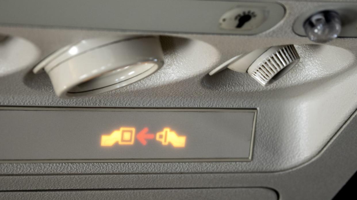 safety sign in airplane, fasten seat belt