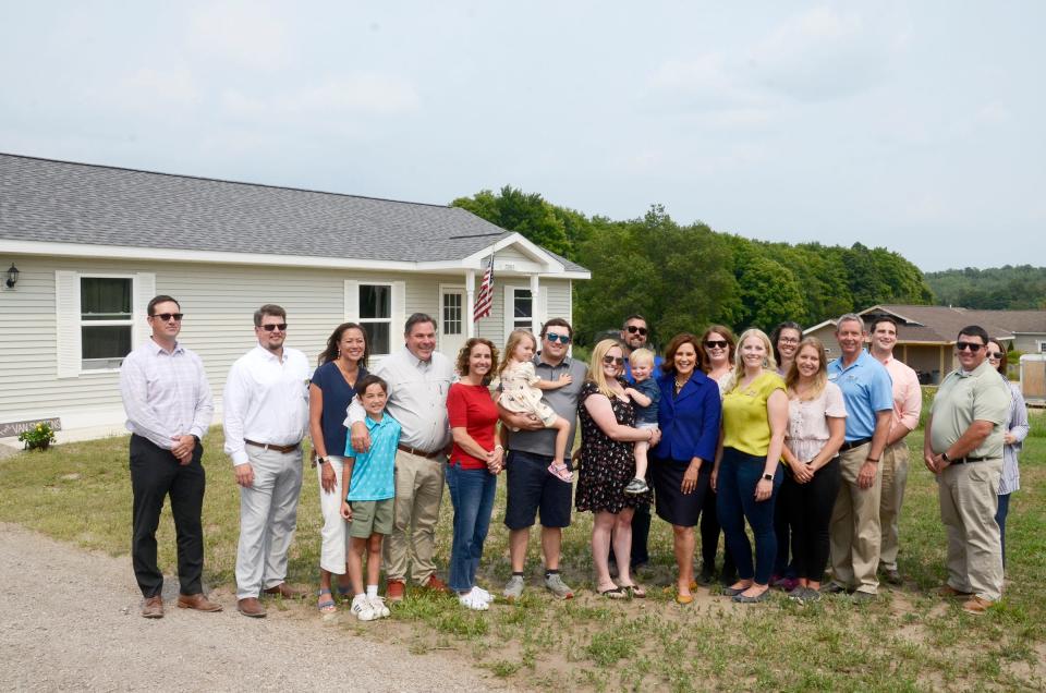 Gov. Gretchen Whitmer and other officials take a photo with the VanSloten family at their home in the Meadowlands subdivision on Tuesday, Aug. 1, 2023.