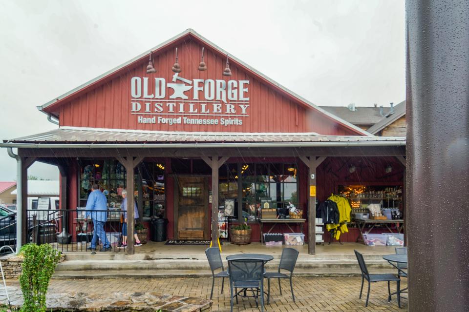 A red building with a triangular roof reads "Old Forge Distillery" at the top of the front facade. Skies are gray behind it.