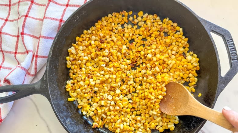 stirring corn in skillet