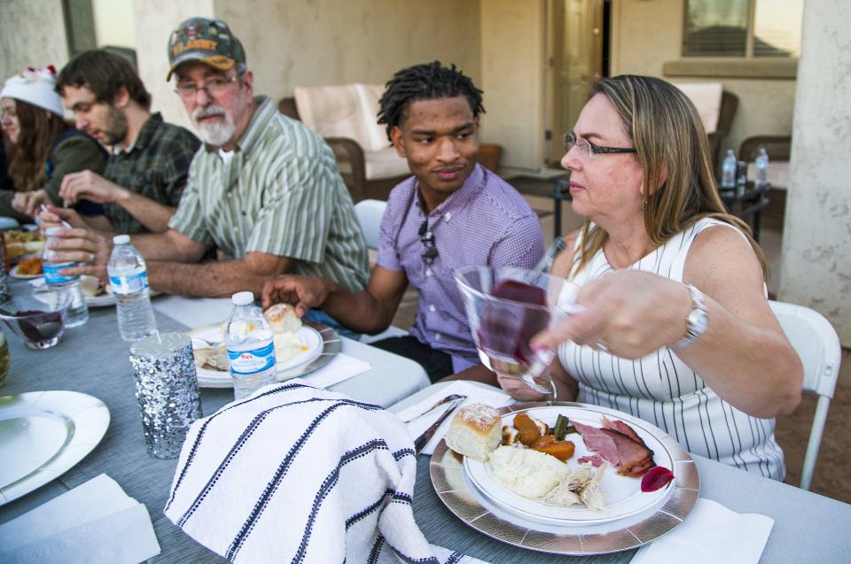 Jamal Hinton, center, joins Wanda Dench, right, and her family and friends for Thanksgiving dinner at Dench's home in Mesa, Ariz., in 2016. Hinton and the Denches have shared the holiday meal every year since.