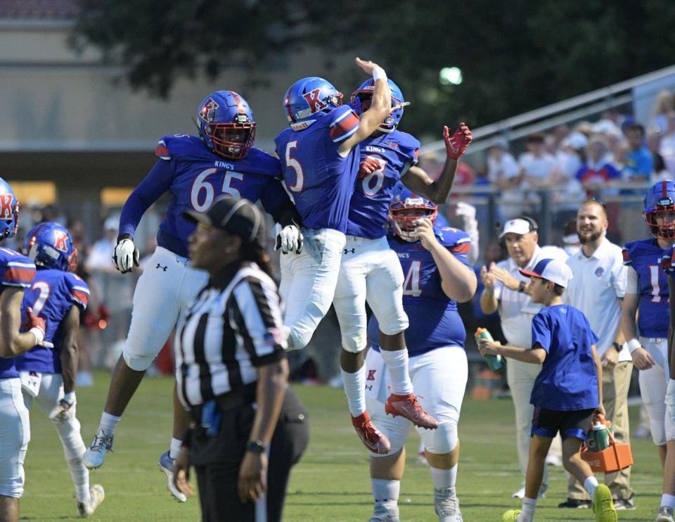 Lions players Dartayvious Saintelus, left, Nick Cueto, middle, and Marion Victor, right, celebrate a Lions touchdown in the first quarter of King's Academy's 24-21 win against St. Andrew's on Friday.