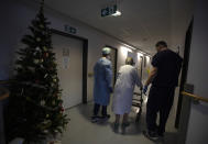 Two Belgian Army medics help a patient to walk who is recovering from COVID-19 at the St. Michiel Hospital in Brussels, Tuesday, Nov. 24, 2020. The Belgian military has been called into several hospitals and care homes to alleviate the stress on healthcare personnel. (AP Photo/Virginia Mayo)