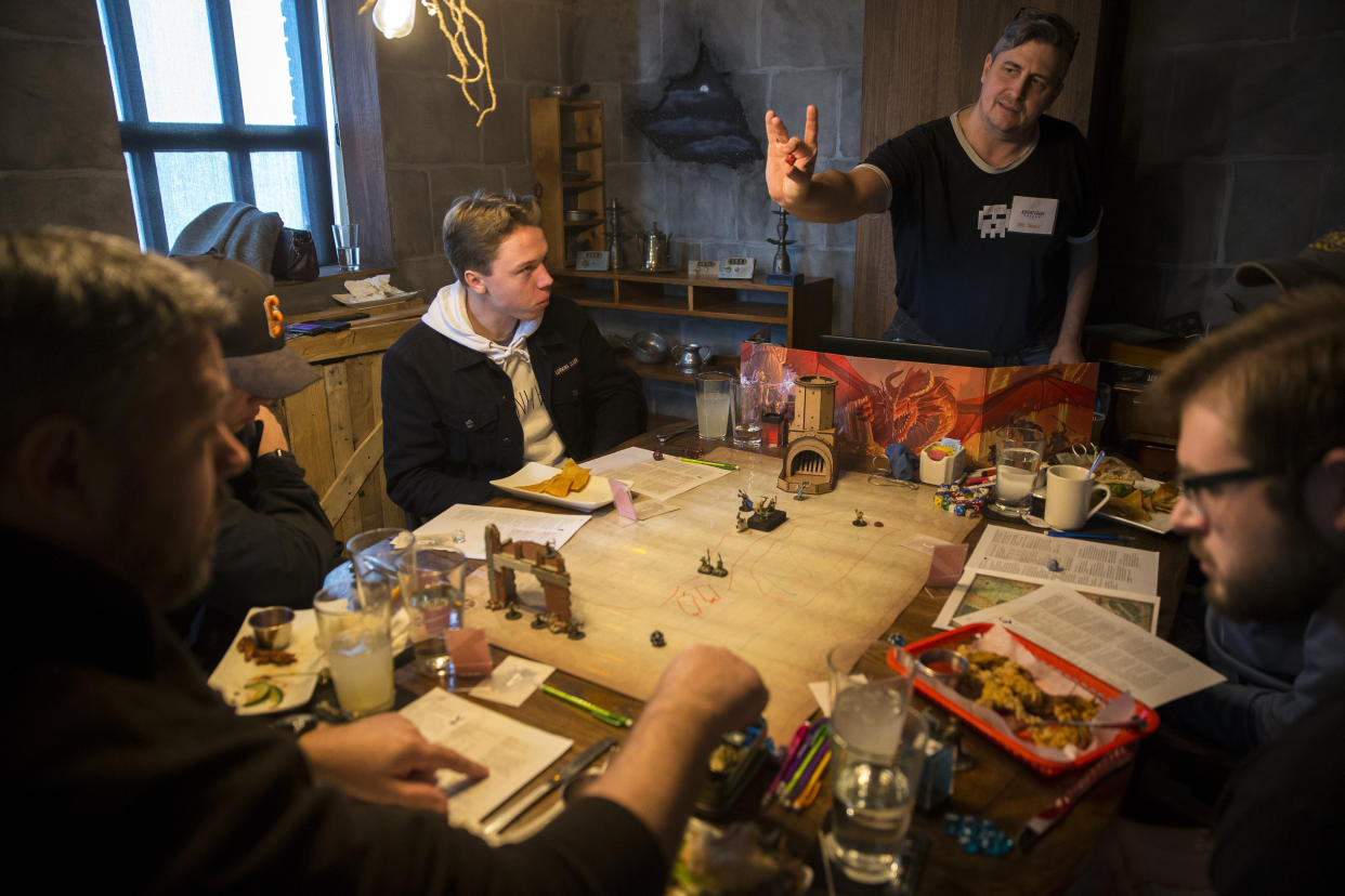 ARLINGTON, MA - DECEMBER 28: Robert Swift of Bedford, Mass. holds out a die while serving as a dungeon master in a game of Dungeons and Dragons at the Adventure Pub in Arlington, Mass. on Saturday, Dec. 28, 2019. In an increasingly high-tech world, board games are gaining a new audience: people yearning to unplug and connect with friends. You can face off against competitors at a gaming store  and even play over beer and burgers at one of a growing number of board game restaurants. (Photo by Nic Antaya for The Boston Globe via Getty Images)