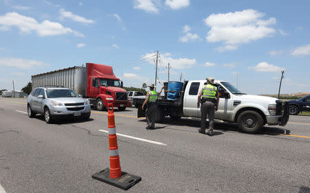 Police keep a roadblock on a main road to Santa Fe High School where police found explosives after an early morning shool shooting that left several people dead in Santa Fe, Texas, U.S., May 18, 2018. REUTERS/Trish Badger