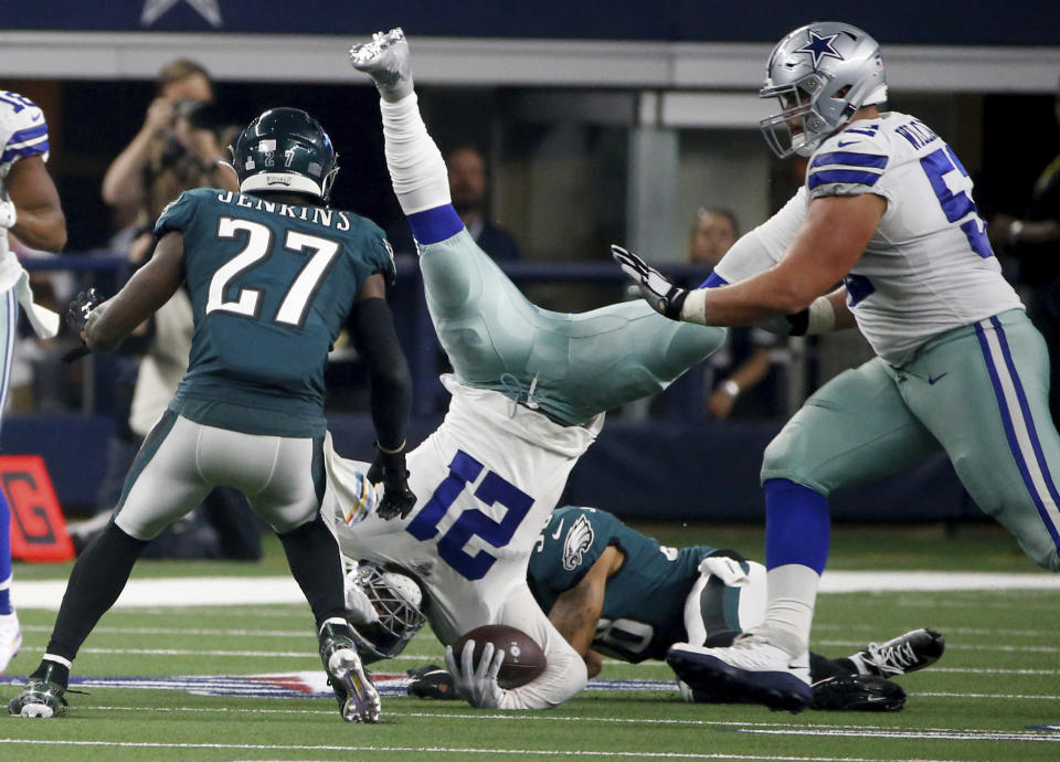 Philadelphia Eagles' Malcolm Jenkins (27) and Dallas Cowboys' Connor Williams, right, look on as running back Ezekiel Elliott, center, is upended by Eagles cornerback Orlando Scandrick, bottom rear, in the second half of an NFL football game in Arlington, Texas, Sunday, Oct. 20, 2019. (AP Photo/Ron Jenkins)