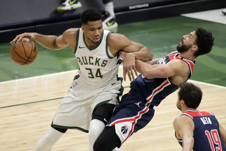 Milwaukee Bucks' Giannis Antetokounmpo (34) commits a charging foul against Washington Wizards' Anthony Gill during the first half of an NBA basketball game Wednesday, May 5, 2021, in Milwaukee. (AP Photo/Aaron Gash)