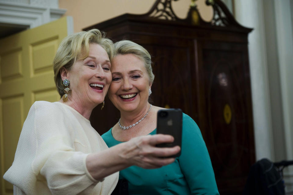 In this Dec. 1, 2012 file photo, Actress Meryl Streep uses her iPhone to get a photo of her and Secretary of State Hillary Rodham Clinton following the State Department Dinner for the Kennedy Center Honors gala at the State Department in Washington.