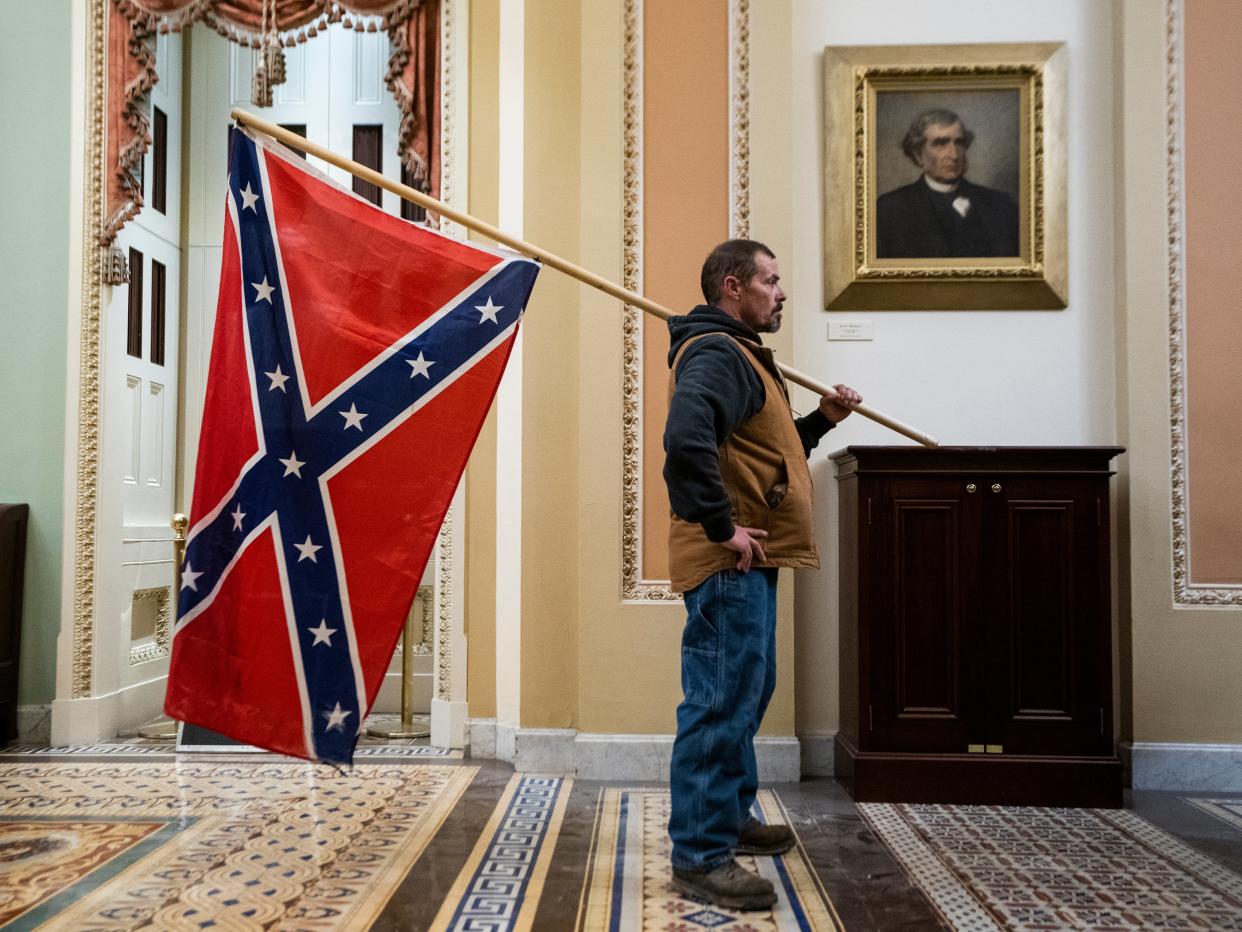 A Trump supporter brings the Confederate Flag into the US Capitol on 6 January (EPA-EFE)