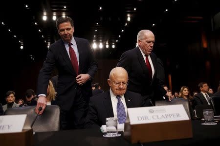 FBI Director James Comey (L), Director of National Intelligence (DNI) James Clapper (C) and CIA Director John Brennan (R) arrive to testify before a Senate Intelligence Committee hearing on "Worldwide threats to America and our allies" in Capitol Hill, Washington February 9, 2016. REUTERS/Carlos Barria