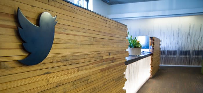 The Twitter logo on the front of a reception desk.