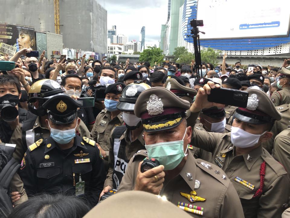 A police officer tries to speak to a crowd at an anti-government gathering Saturday, Aug. 8, 2020, in Bangkok, Thailand. Political tensions are rising in Thailand as pro-democracy activists vowed to step up protests against the government and police arrested some key figures in recent demonstrations. (AP Photo/Jerry Harmer)