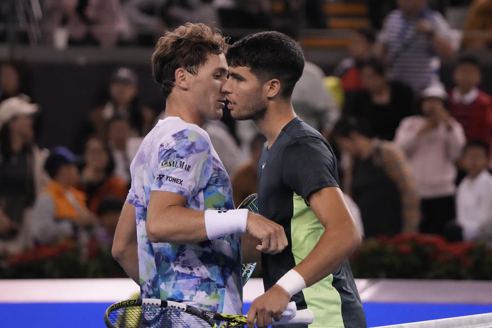 Carlos Alcaraz of Spain, right, hugs Casper Ruud of Norway after winning the men's singles quarterfinal match in the China Open tennis tournament at the Diamond Court in Beijing, Monday, Oct. 2, 2023. (AP Photo/Andy Wong)